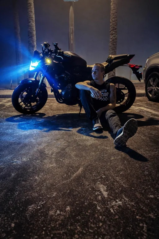 Vladimir Bunchuk beside a motorcycle at night